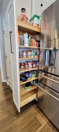 an organized pantry in a kitchen with stainless steel appliances and wood flooring is shown