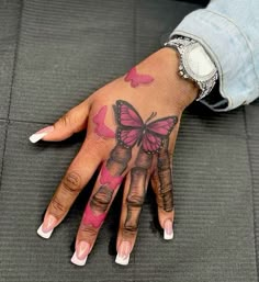 a woman's hand with pink butterflies on it