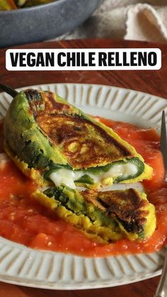 an egg omelet is on a plate with tomato sauce and avocado