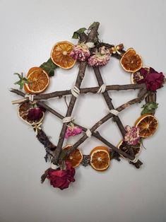 an arrangement of dried fruit arranged in the shape of a pentagram with leaves and flowers