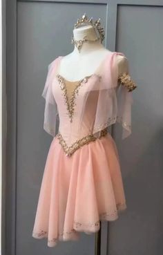 a pink dress with gold sequins on the top and bottom, sitting on a mannequin