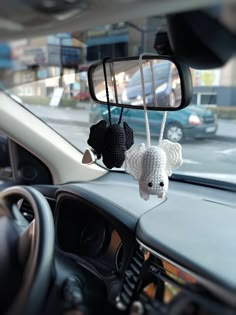 a car dashboard with two stuffed animals hanging from it's rearview mirror