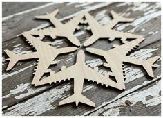 four wooden airplanes are arranged in the shape of a snowflake on an old wood background