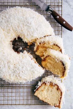 coconut bundt cake with one slice cut out on a cooling rack next to a knife