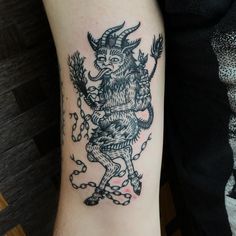 a black and white tattoo on the arm of a person with a horned animal design