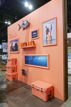 an exhibit with orange boxes and pictures on the wall