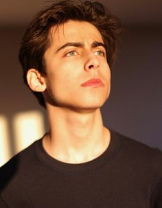 a young man looking up at something in the air with his eyes wide open and one eye half closed