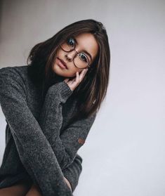 a woman wearing glasses posing for the camera