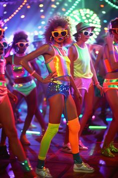 a group of women in neon colored clothing and sun glasses on the dance floor at a nightclub