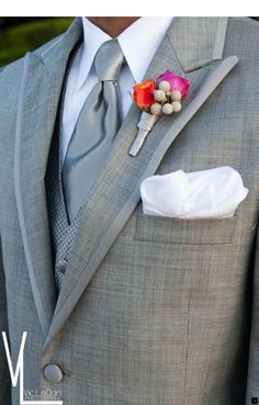 a man in a gray suit with a flower on his lapel