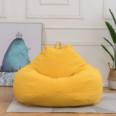 a bean bag chair sitting on top of a wooden floor next to a potted plant