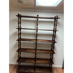 an old wooden book shelf in the corner of a room with a skylight above it