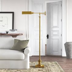 a living room with a white couch and gold floor lamp