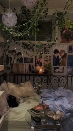 a bedroom with pictures on the wall and plants hanging from the ceiling