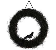 a black bird sitting on top of a wreath