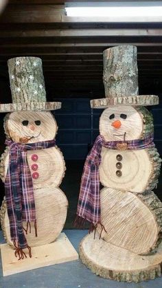 two snowmen made out of wood sitting next to each other