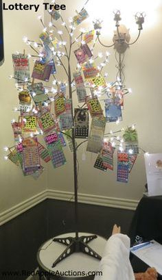 a tree with lots of cards attached to it and lights on the branches in front of it