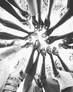 a group of people standing in a circle with their hands together and looking up at the camera