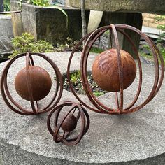 three metal balls sitting on top of a stone slab