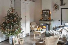 a living room filled with furniture and a christmas tree on top of a wooden table