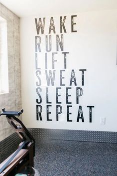 a treadmill in front of a wall that reads wake run, sweat sleep repeat