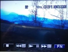 the screen is showing an image of mountains and trees in blue tones with white letters