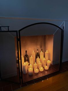 a fireplace with many lit candles in front of it