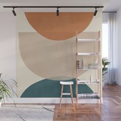 an abstract painting on the wall in a living room with wooden floors and white walls