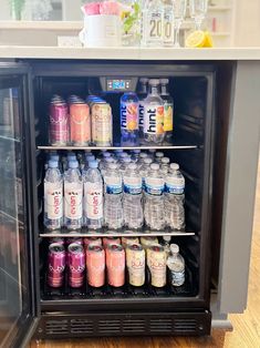 a refrigerator filled with lots of different types of drinks next to a counter top freezer