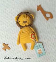 a crocheted lion with a tag next to it's keychain