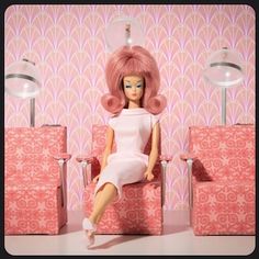 a doll sitting in a chair with pink hair