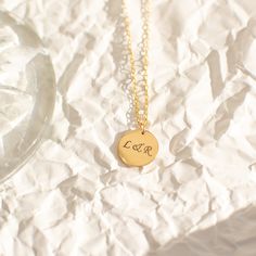 "Not too big and not too small, our 13mm circle necklace, fits just right. A perfect everyday necklace that will layer beautifully with your other chain and pendant necklaces. Engrave a heartfelt word, a special year, or a short name of a loved one. Free Engraving for a limited time! NECKLACE DETAILS ⚬ 14k gold-filled disc and chain. ⚬ Disc measures 13mm (0.51\") ⚬ Chain in your choice of 16\", 18\", or 20\" length ⚬ Spring ring clasp closure. ⚬ Personalized engraving of 1-4 characters (includin 14k Gold Charm Necklace With Round Pendant For Her, 14k Gold Filled Round Charm Necklace, Dainty Round Initial Necklace As Gift For Her, Minimalist Round Initial Necklace In 14k Gold Filled, Minimalist Round Disc Necklace For Anniversary, 14k Stamped Coin Necklace As Gift, Minimalist Disc Necklace For Anniversary, Personalized Round Initial Necklace For Her, Personalized Round Initial Necklace As Gift For Her