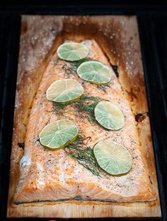 a piece of salmon with lime slices on it