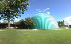 a large green dome sitting on top of a lush green field