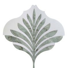 a white and green leaf shaped mirror on a wall