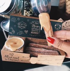 a person is holding an ice cream filled donut in front of some desserts