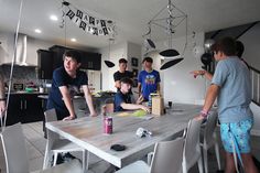 a group of people standing around a kitchen table