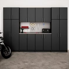 a motorcycle parked next to a garage with cabinets on both sides and a bike in the middle