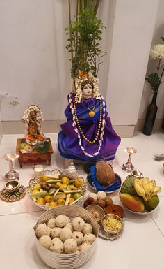 an assortment of food on a table with buddha statue in the middle and other items around it