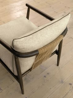 a chair that is on the floor with wood and fabric upholstered to it