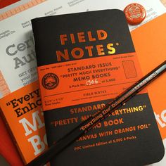 an orange and black field notes sitting on top of each other