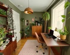 a room with a desk and plants in it