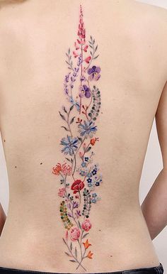 the back of a woman's body with flowers painted on her stomach and lower back