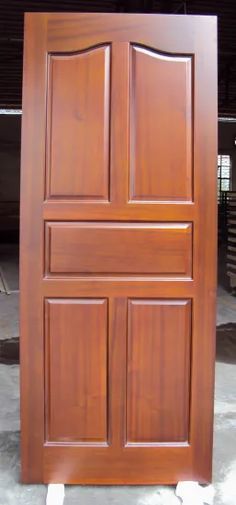 a close up of a wooden door on concrete