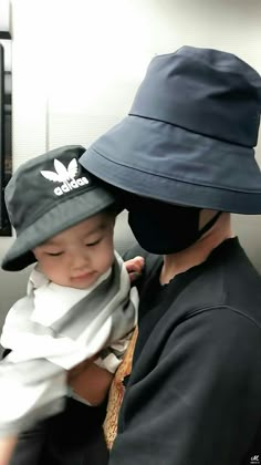 a man holding a child wearing a hat