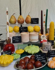 a table topped with lots of different types of fruits and veggies next to candles