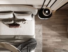 an overhead view of a bed with white sheets and pillows on top of it, next to a lamp