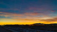 an airplane is flying in the sky at sunset