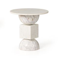 a white table with two marble pedestals on top