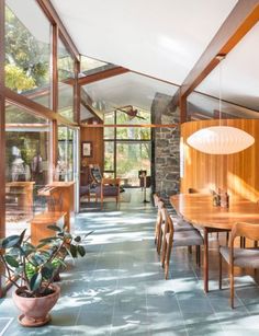 an image of a dining room with wood furniture and large glass doors that open up to the outdoors